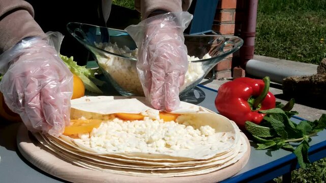 the process of cooking pita bread with cheese yellow tomatoes in sunlight cooking pita bread for lunch. High quality 4k footage
