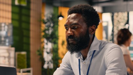 Naklejka premium African American man, working with laptop, modern office, visual data, KPI metrics, business intelligence, planning for development, performance review, research and development.