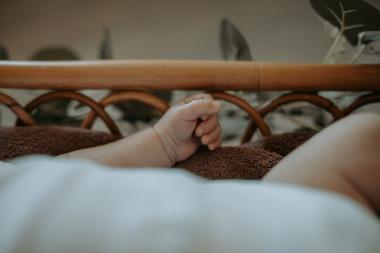 Main de b&eacute;b&eacute; dans un berceau en bois