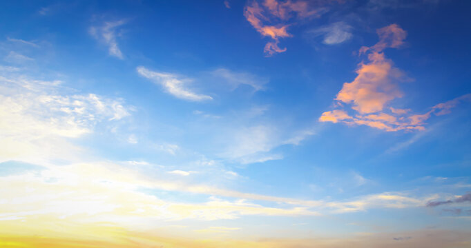 Beautiful vibrant blue sky background with golden orange clouds at sunset for inspirational nature wallpaper
