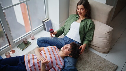 Obraz premium LGBTQ partners relaxing home talking enjoying calm weekend. Smiling brunette 