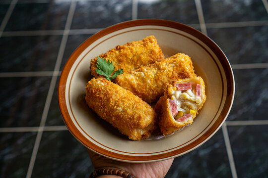 Crispy Homemade Risoles Filled with Ham, Cheese and Vegetables on Rustic Wooden Table