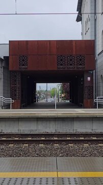Railway station platform with metal pedestrian overpass