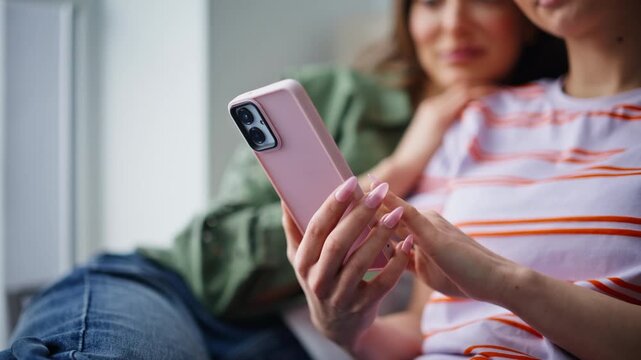 Bestie watching cellphone content sitting closely home closeup. Carefree women 