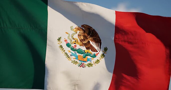 Dynamic Mexico National Flag Waving in the Wind, Showcasing Vibrant Colors and Rich Cultural Emblem Against Blue Sky