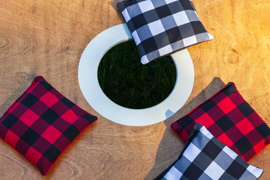 Overhead close up view of a corn hole game with bags on a sunny summer day