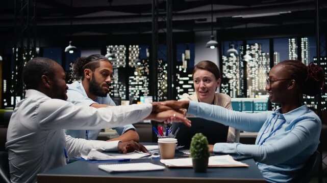 Diverse group of people uniting hands and celebrating a victory, breakthrough in project management to meet business objectives. Coworkers proud about efficient teamwork and success.