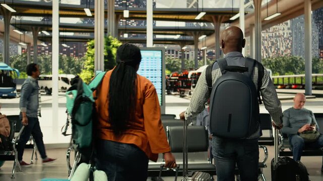 African american couple approaching departure board for intercity bus timetable, carrying backpack and preparing for long-distance cross-country journey for job travel. Express line.