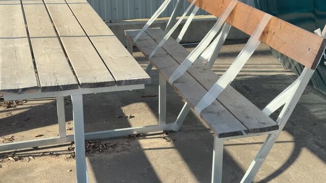 Metal gazebo with table and benches displayed in hardware store lot with corrugated roof, metal frame and wooden plank seats