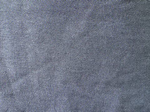 Robust indigo twill textile presenting a subtle diagonal weave pattern and durable texture
