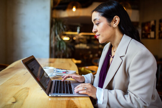 Professional woman working on laptop in cafe