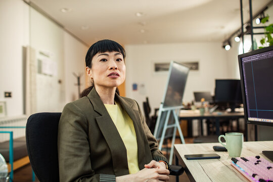 Confident businesswoman working at computer in modern office