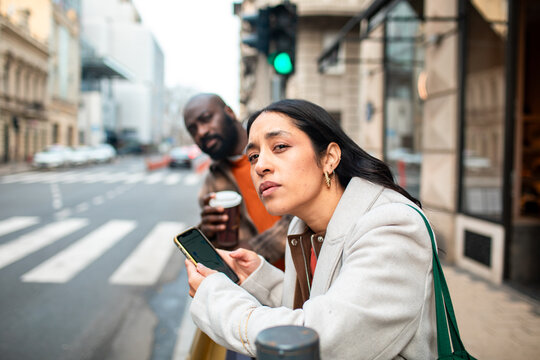 Two people using phone for directions on a city street