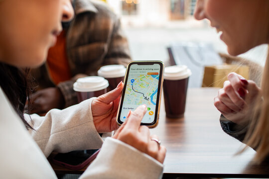 Friends using a ride-hailing app at a cafe