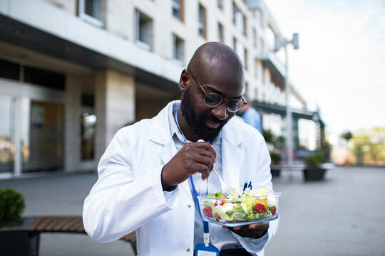 Doctor eating healthy salad during break outside hospital
