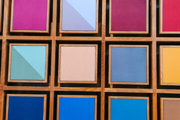 Fototapeta premium Abstract Geometric Wall Art with Colorful Square Panels in Wooden Grid, Modern Interior Design Background for Creative Office or Gallery. Flexible Layout. Copy Space.