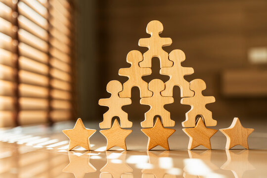 Wooden human figures stacked in a pyramid shape on five stars rating with bright sunlight. Concept of successful teamwork, top performance, excellent human resources, and leadership.