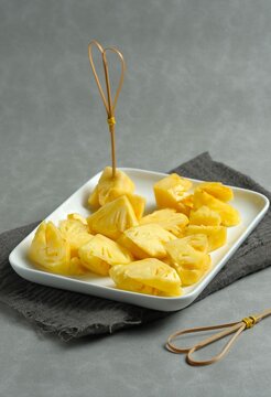 Fresh sliced pineapple pieces served on a plate. juicy, ripe yellow pineapple chunks and slices neatly arranged on a ceramic plate, perfect for a healthy snack or tropical dessert concept