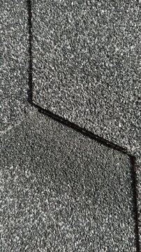 Black hexagon asphalt shingles closeup showing granular surface and staggered layout, flexible roof tiles for cottage, black