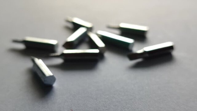 Scattered screwdriver bits on surface, showing mechanical tools and workshop equipment detail in close-up view.