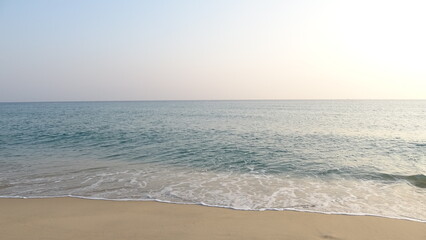 Fototapeta premium Calm Ocean Horizon and Waves on Sandy Beach. A peaceful and minimalist landscape of the East Sea coast during early morning in Gangneung, South Korea.