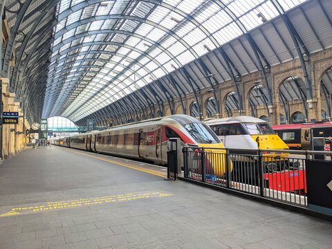 Modern LNER Azuma trains stationary at platforms under the iconic glass roof of King's Cross Station