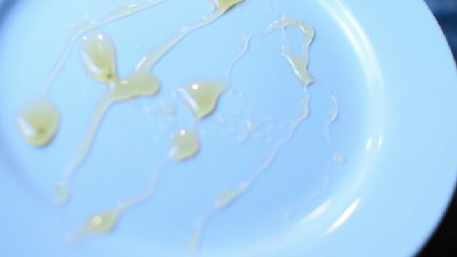 Honey scattered all over a white glass plate. 