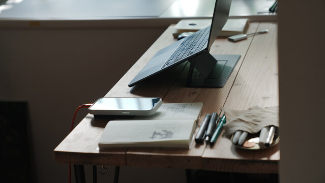 Home Desk Setup with Laptop on Stand, Smartphone and Notebook, Productive Workspace