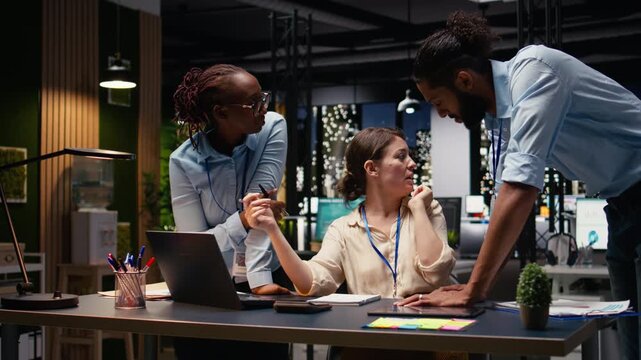 Diverse man and women working together on project in corporate space, collaborating on business intel data research. Coworkers brainstorming ideas, managing assignments for strategic goals.