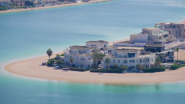 Dubai luxury beachfront mansions and villas on artificial palm island surrounded by calm turquoise waters. White Mediterranean-style homes with private beaches and palm trees on exclusive waterfront.