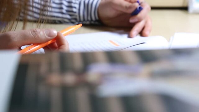 학생 책상 공부 형광펜 밑줄 필기 손동작 디테일 자재: 실내 책상에서 줄무늬 셔츠를 입은 사람이 주황색 형광펜으로 문제집 서류에 밑줄을 그으며 학업에 몰두하는 손동작을 포착한 클로즈업 영상입니다. 서적 보케를 담았으며 시험 공부, 자기계발, 교육 컨텐츠 및 라이프스타일 콘셉트의 역동적인 인서트 숏입니다.