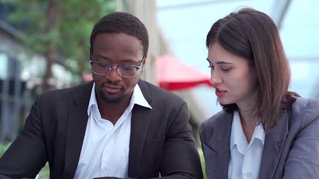 Diverse business partners discussing a project outside office