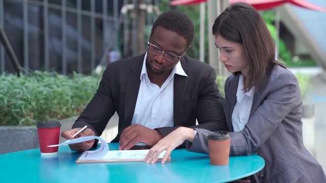 Diverse business partners discussing a project outside office