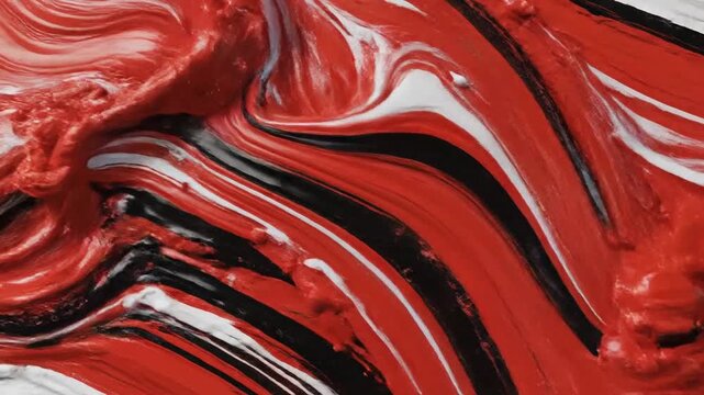 Thick red, black, white paint slowly swirls, blending into an abstract art texture