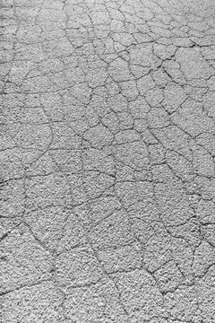 Photo of a cracked asphalt surface. Cracks on a concrete road.