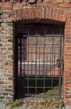Vintage metal grate in a brick wall above the Radunia Canal near the historic Great Mill building.