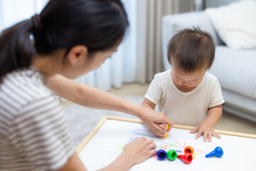 Obraz premium Asian mother drawing together with her toddler son indoor