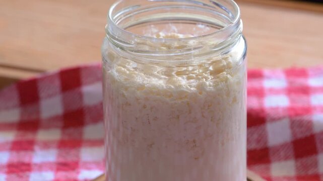 Close up of milk kefir grains in a glass jar