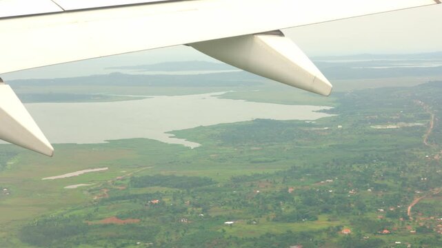 High Angle View of Lake Victoria capturing the lush green landscape, scattered houses, and rural villages of Uganda, filmed during a flight near Entebbe.