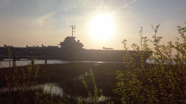 Gimbal wide panning shot of the historic USS Yorktown CV-10 docked at Patriots Point during sunset in Charleston, South Carolina. 4K at 60 FPS Slow Motion