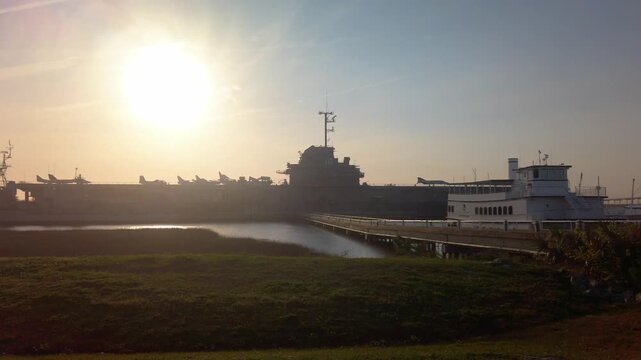 Gimbal wide panning shot of the historic USS Yorktown aircraft carrier at sunset in Charleston, South Carolina. 4K