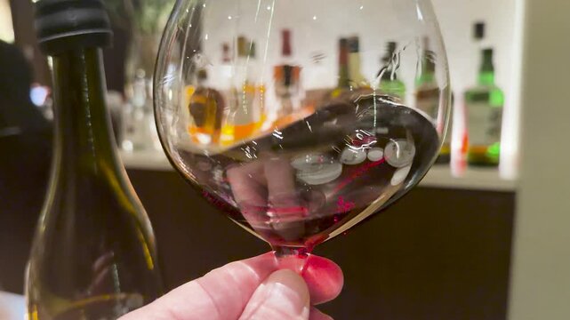 Red Wine Swirling in a Large Glass at a Luxury Bar