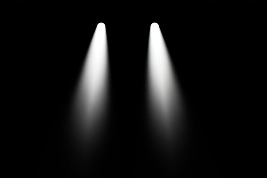 Two bright stage lights beam across a dark background.