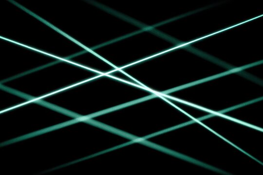 Dynamic teal laser beams creating abstract patterns against a dark background.