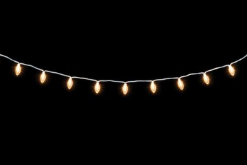 Fototapeta premium Warm white string lights glowing against a dark background