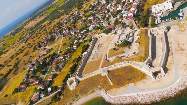 Seddulbahir, Eceabat, Turkey. Sedd el Bahr Fortress, its angular stone bastions and weathered ramparts dominating the turquoise Dardanelles coastline, aerial drone view under clear summer sun. Aerial