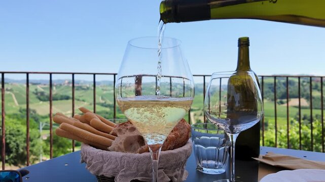 White Wine Poured into Glass on Balcony Overlooking Italian Vineyards