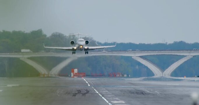 Plane landing in slow motion at DCA Reagan National Airport on gloomy overcast morning