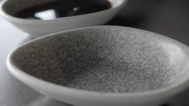 pouring soya sauce in a small container 