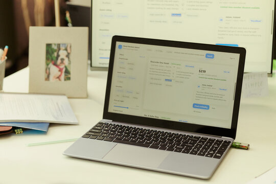 Close up of laptop displaying hotel booking platform on office desk, showing travel planning and online reservation workflow. Ideal for tourism marketing, booking app promotion